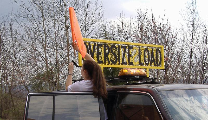 Travelers&Kaite.jpg - BTI's Kaite is demonstrating how easy it is to install the flags on a BTI oversize load sign.